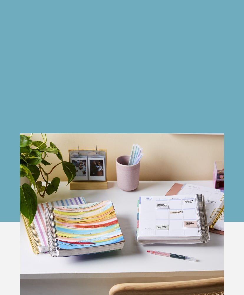 View of assorted coiled planners on a desk with accessories