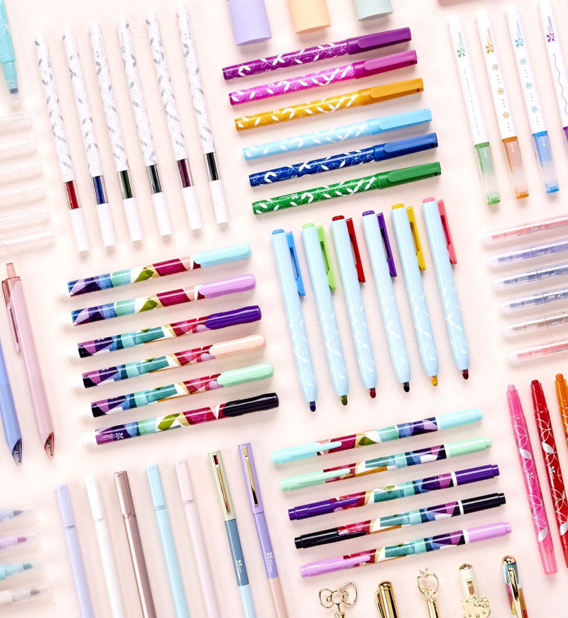 Overhead view of assorted writing tools. Click to shop now.