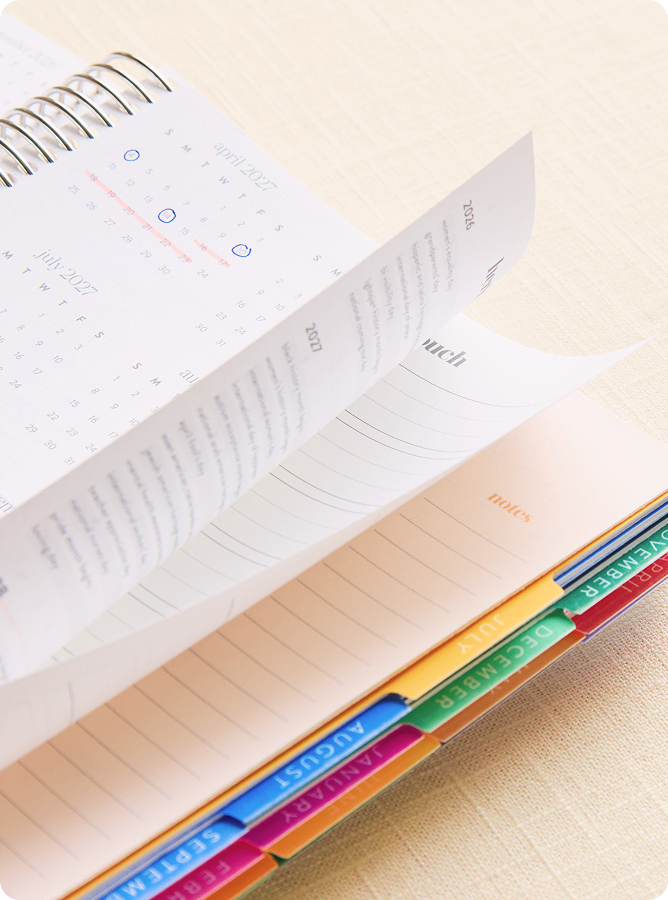 person flipping through coiled lifeplanner featuring Bouquet design.