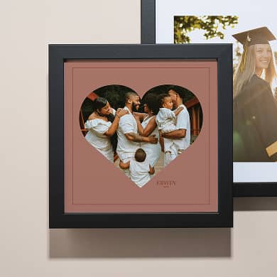 two stacked framed photos, one of a woman graduating and one of a family with children. Click to shop custom photo art.