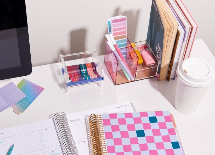 Office supplies and coiled planners on a desk.
