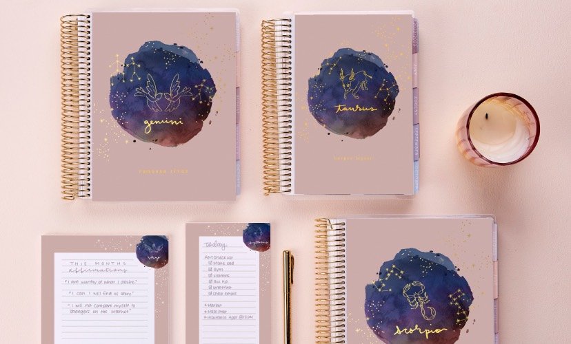 overhead view of assorted coiled planners and stationery featuring new astrology designs