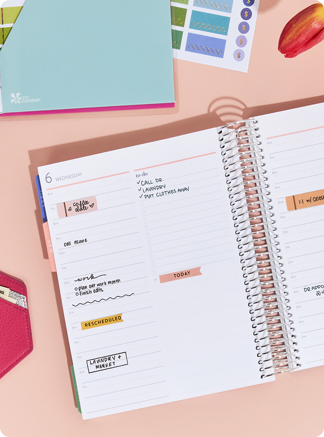Close up of coiled lifeplanner featuring daily layout with notes and stickers.