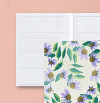 two undated softbound planners. One open showing layout, one closed on top with floral cover. Click to shop Undated Softbounds.