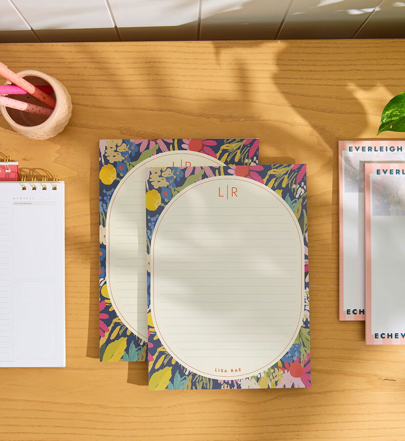 NEW Custom Notepads in NEW designs on a desk with accessories. Click to shop now.
