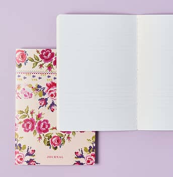 Lined petite journal on top of closed petite journal featuring roses on cover. Click to shop petite journals.
